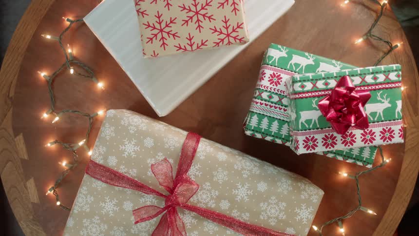 Presents sitting on a table with christmas lights