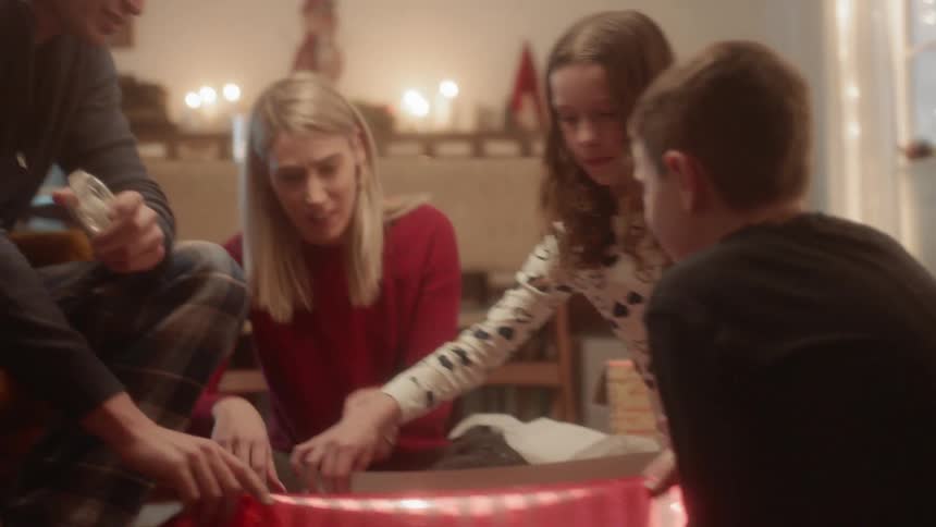 A family wraps a christmas gift