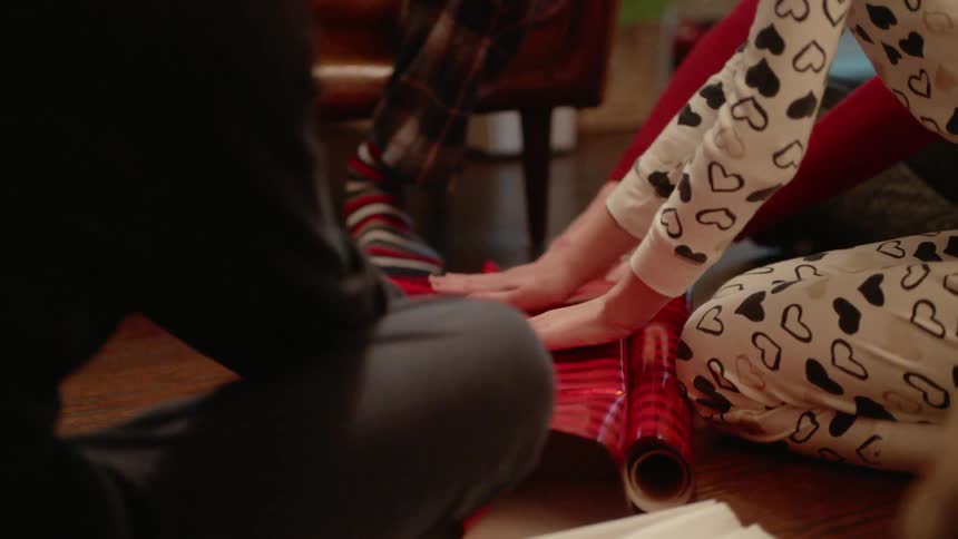 A family wraps a christmas gift