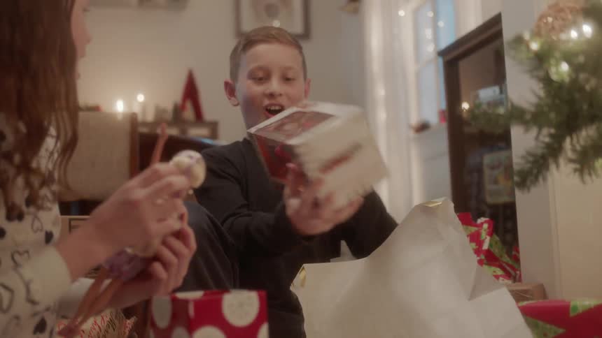 A boy and girl open christmas presents