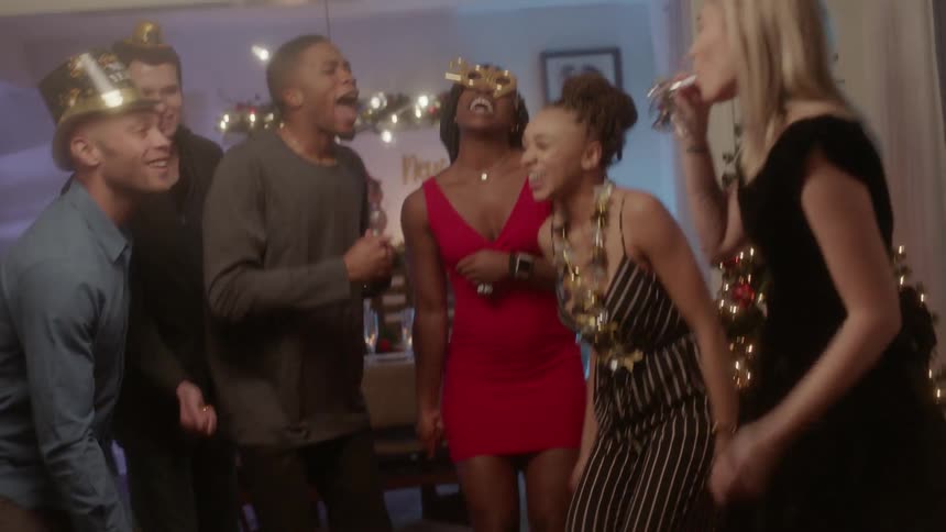 Friends celebrate next to a christmas tree