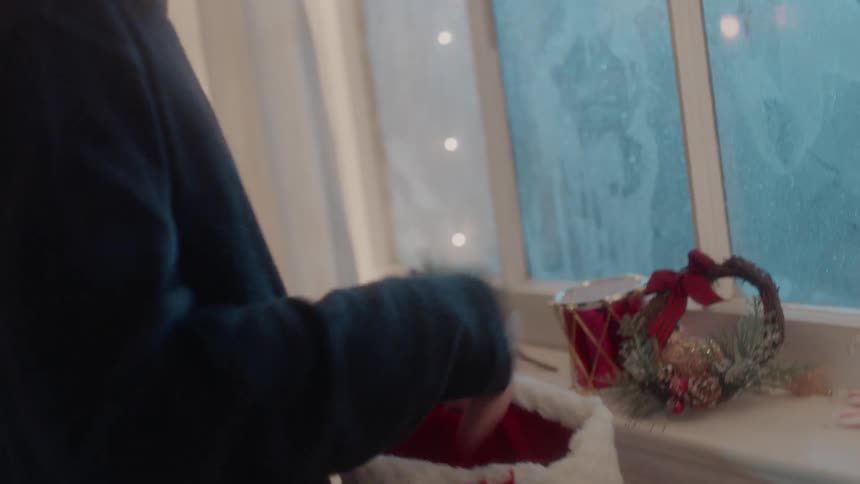 A boy pulls candy canes from a christmas stocking