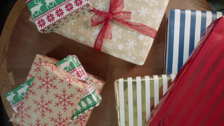 Wrapped christmas presents sit on a table