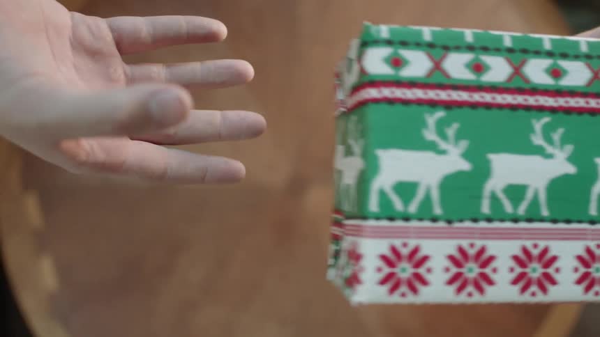 People pass a present over a table