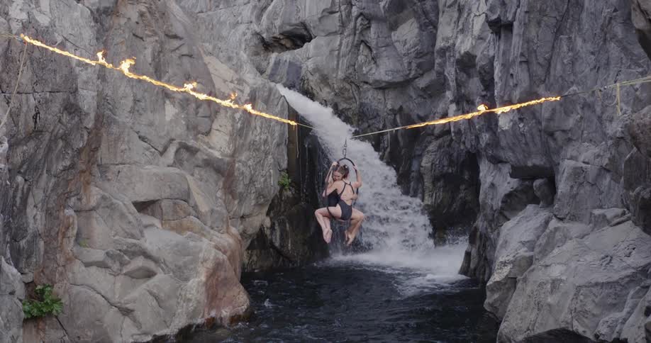 Two women turn in a ring hanging from a flaming tightrope