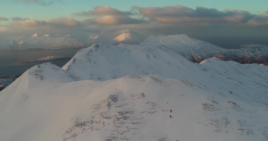 Two climbers ascend a snow covered mountain range