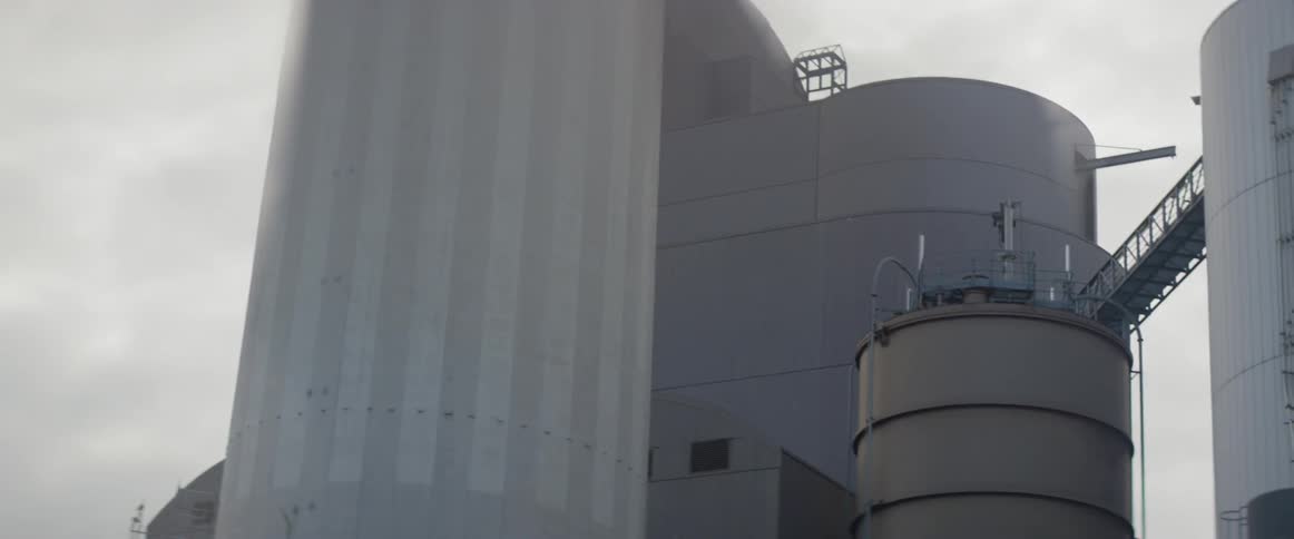 Very large water tanks against a cloudy sky