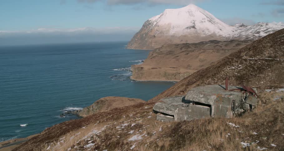 A bunker is sitting on the side of a hill overlooking the ocean