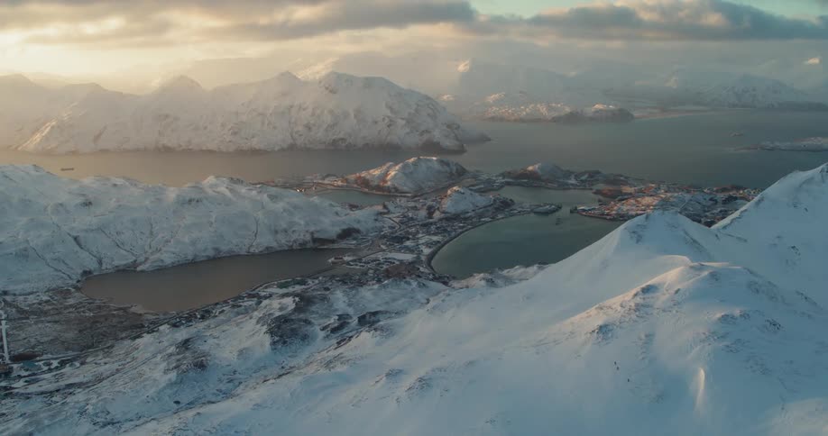 The sun sets over snowy mountains