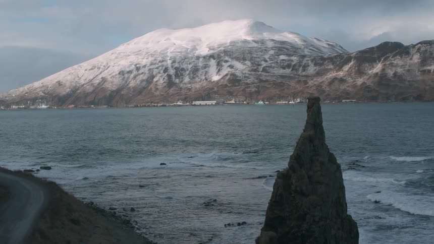 Waves are rolling toward the shore on a remote coast on a winter's day