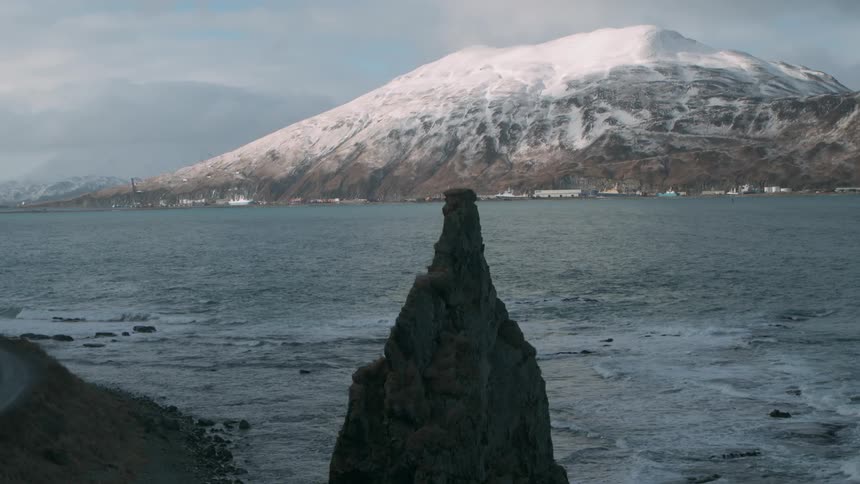 Waves are rolling toward the shore on a remote coast on a winter's day