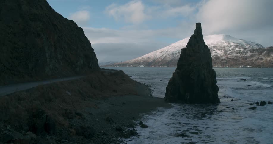 Waves are rolling toward the shore on a remote coast on a winter's day