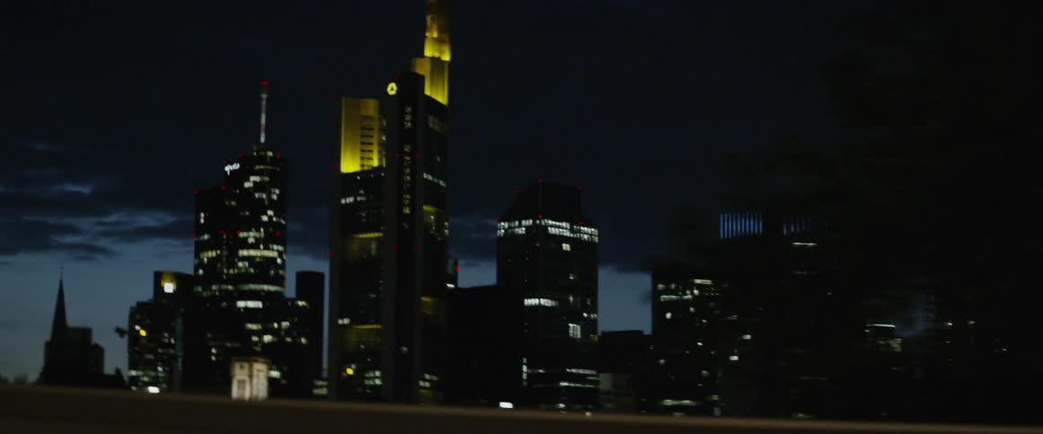 A big city skyline at night from a car passing a on a bridge