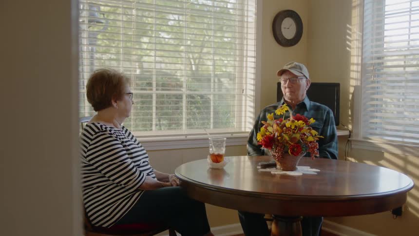 Man and woman talk at a dining room table