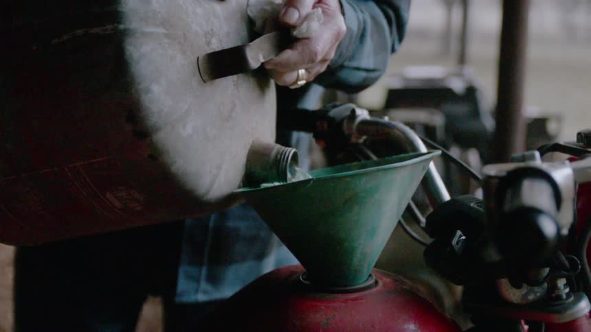 A man adds gasoline to a motorcycle