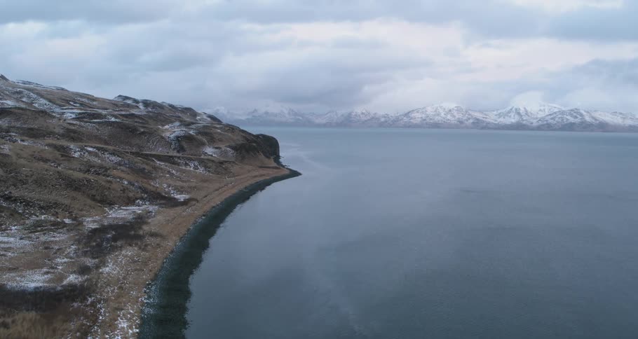 Snowy mountains sit next to the sea