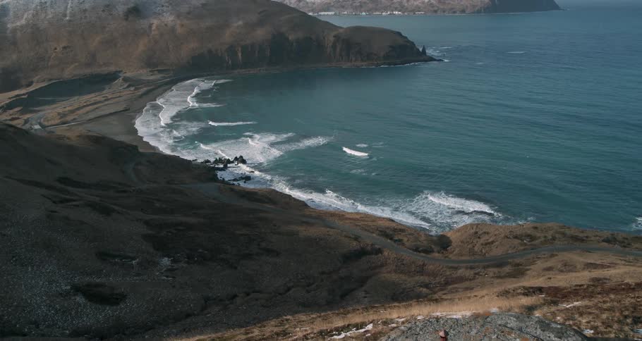 A cement bunker sits on a hilltop overlooking the ocean shore