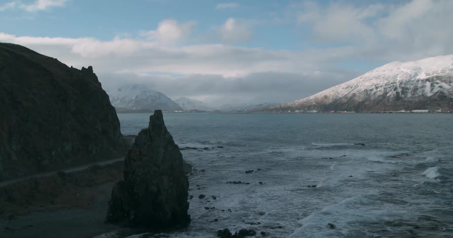 Rough waters crash against the rocky shore