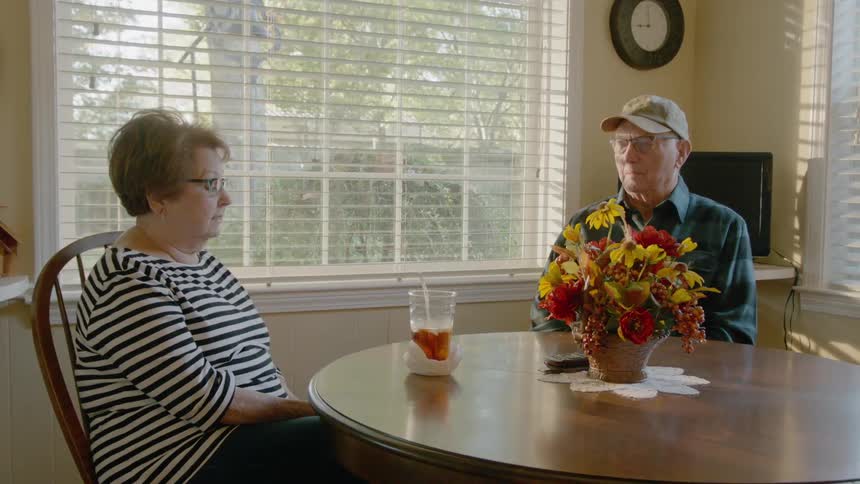 Man and woman talk at a dining room table