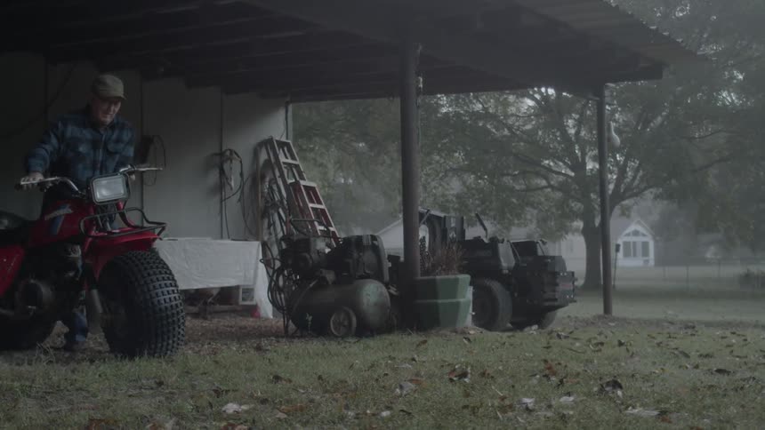 Elderly man turning on a three-wheeler at his home