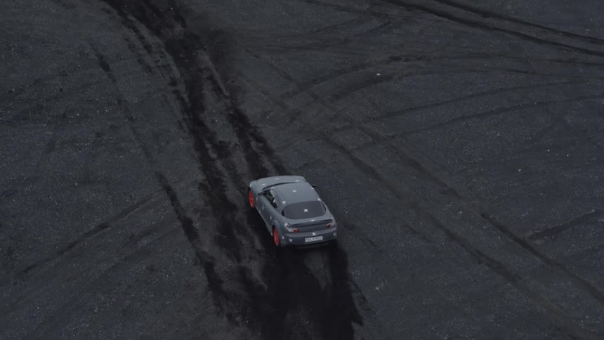 Car travels through a field leaving tire marks