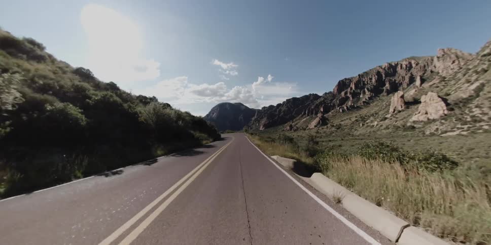 A rural road bends and curves on a sunny day