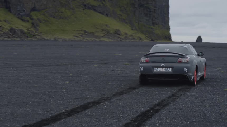 A sports car leaves tire tracks as he travels through dirt and sand