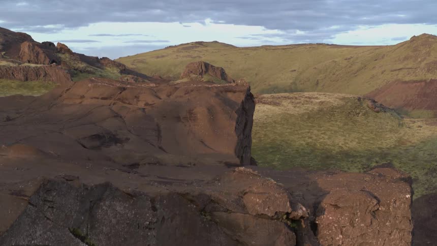 A small rock cliff is filmed by a drone