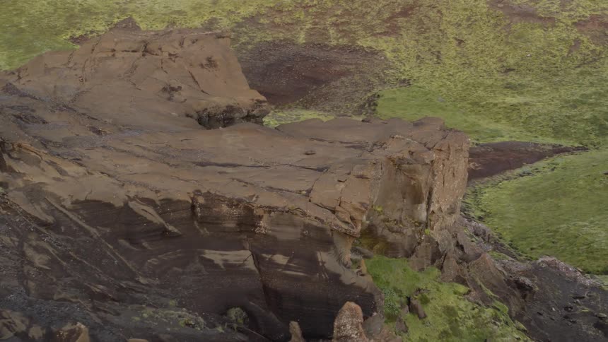 A rocky cliff is shown in the wilderness