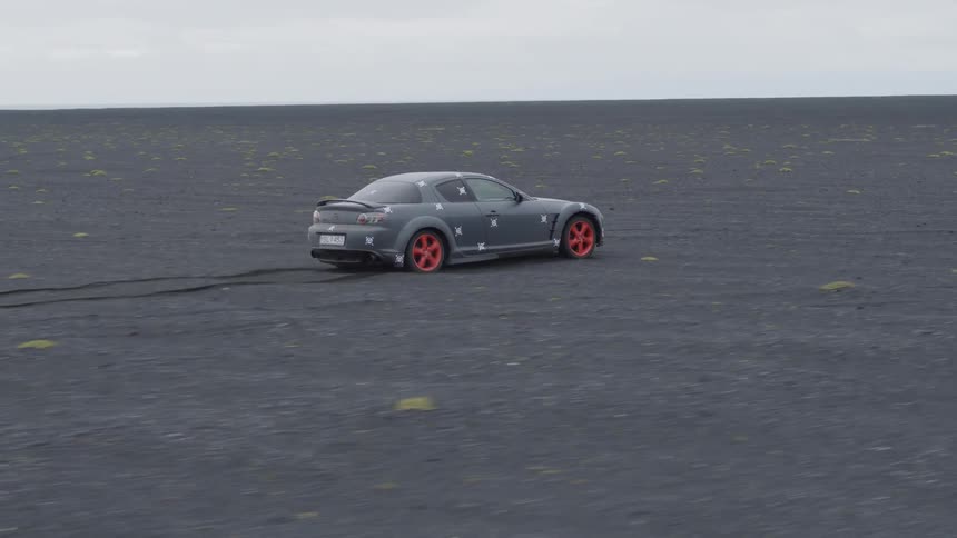 A sports car is off-roading on a beach during the day