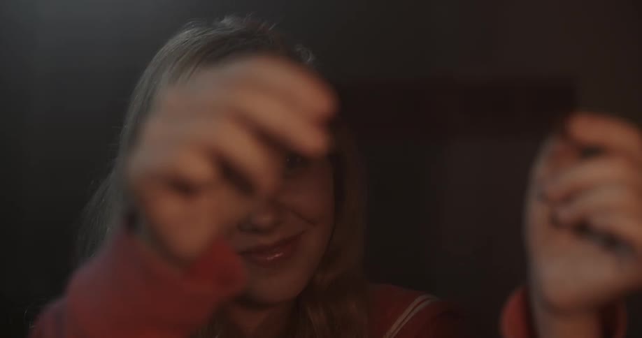 A woman holds a film reel up to a light