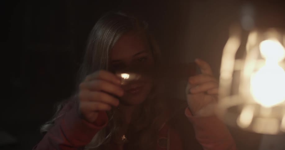 A young woman holds a strip of film to a light