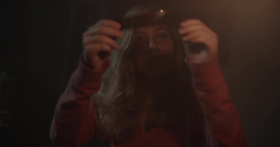 Girl holds film negative up to light to see it
