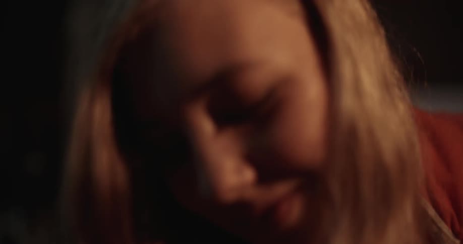 A girl is smiling in a dark area