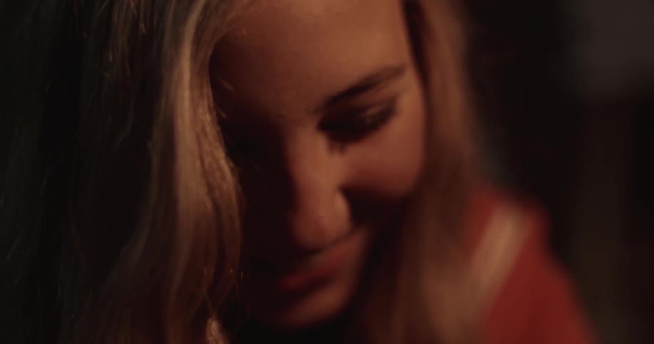 A girl is smiling in a dark area