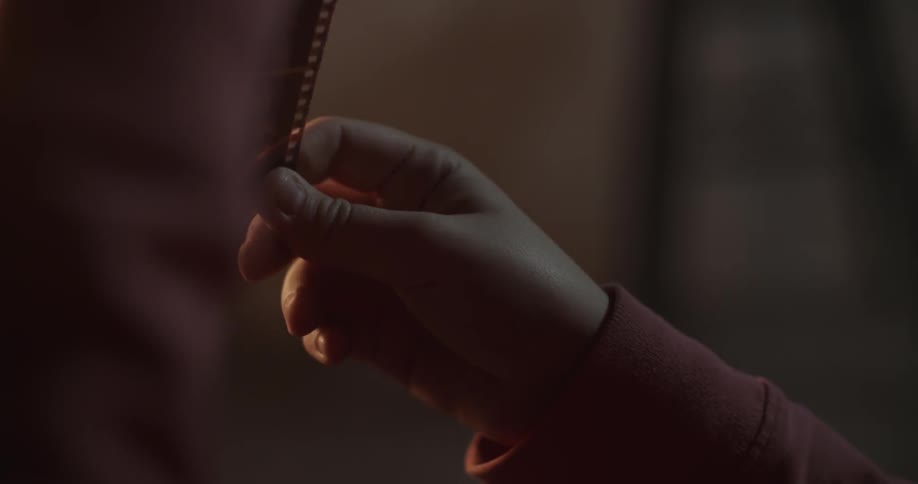 A person is examining a roll of film