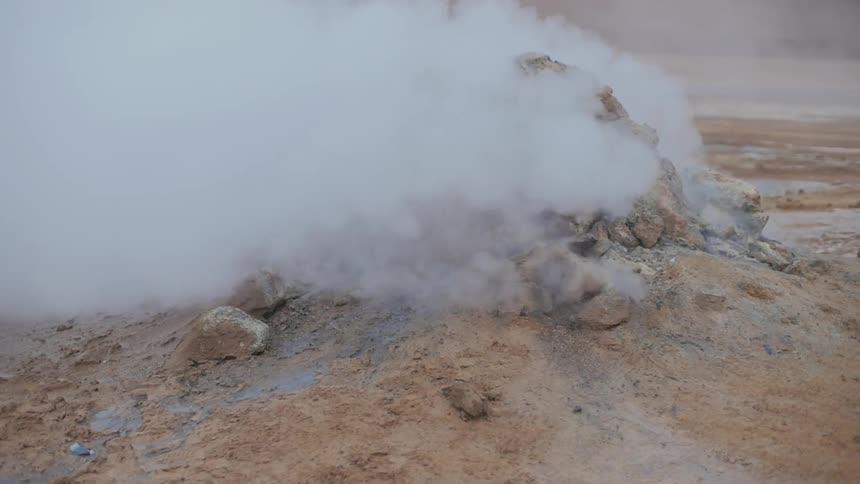 Heavy steam coming out of some rocks on the ground