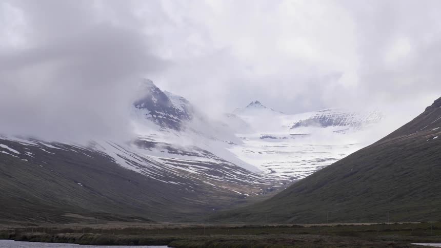 Time lapse of some clouds traveling on the surface of a snow covered mountain