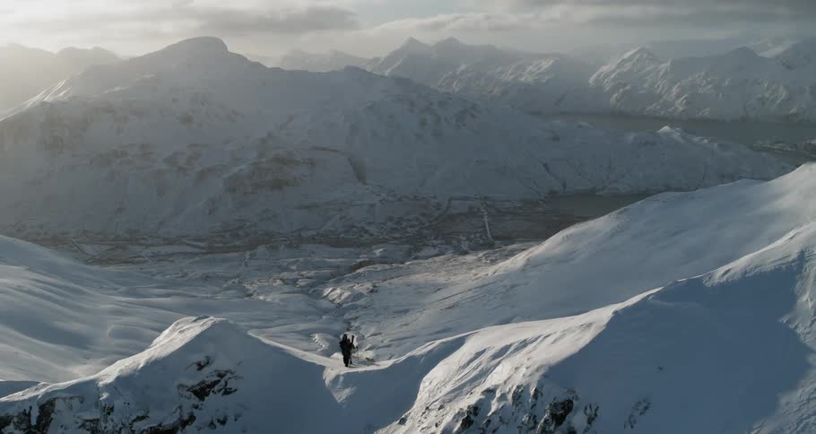 Skiers atop a snowy ridge
