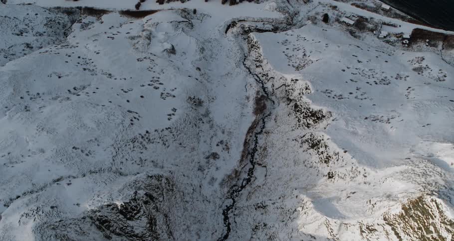 The sun shines down on snow covered ridges and rock