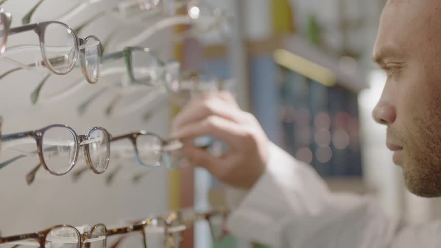 Someone is picking out eyeglasses from a eyeglasses store