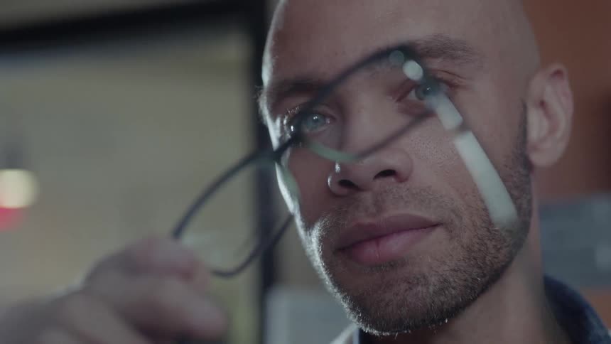 Man looking at a set of eyeglass frames in a store