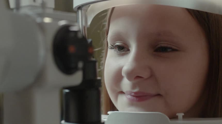 A child is having her eyes examined