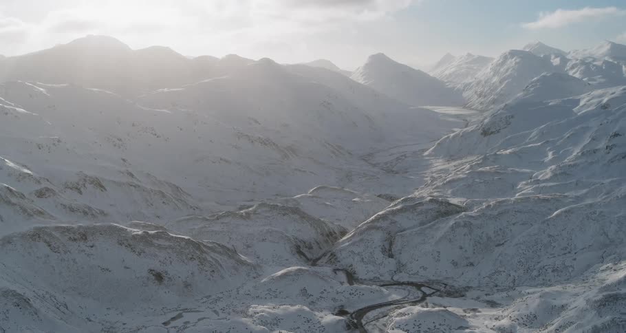 The sun shines over snowy mountains