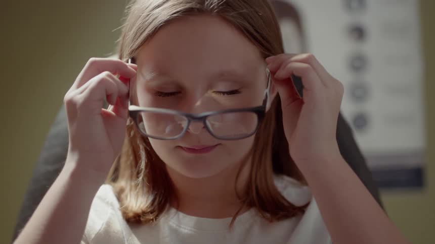 Girl tries on a pair of eyeglasses