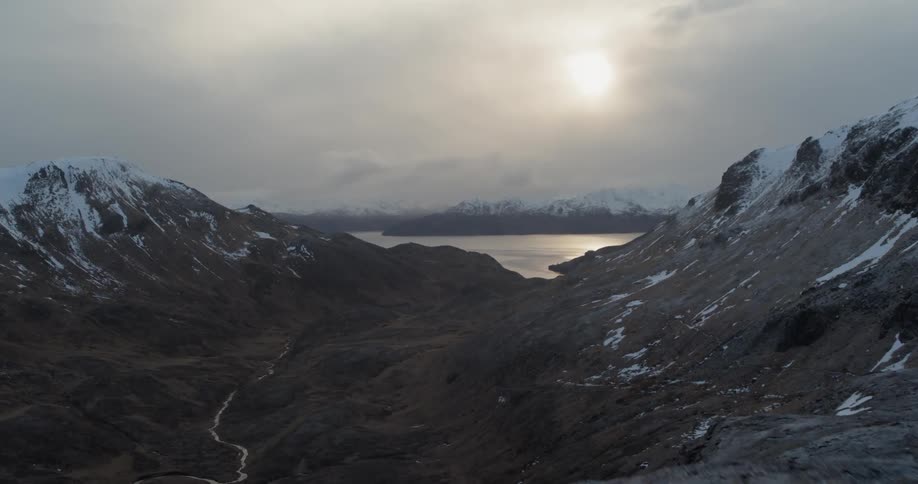 The sun sets over snowy mountains