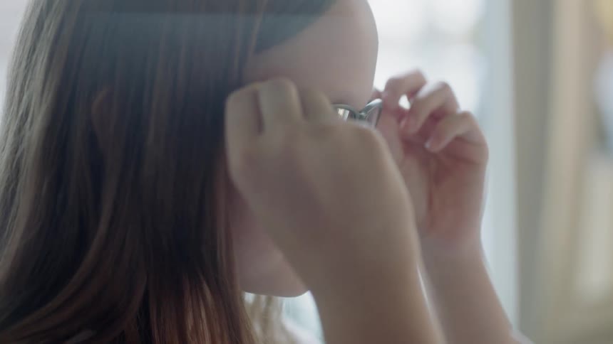Child puts glasses on and smiles