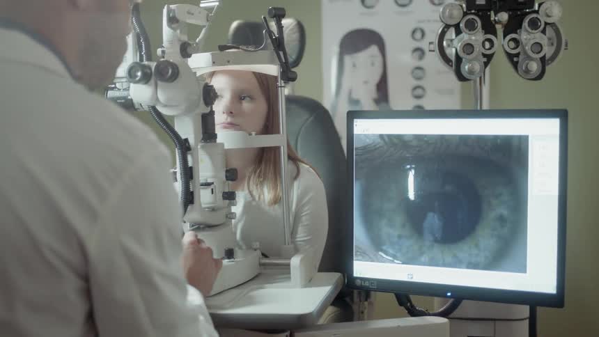 An optometrist examines a girl's eyes