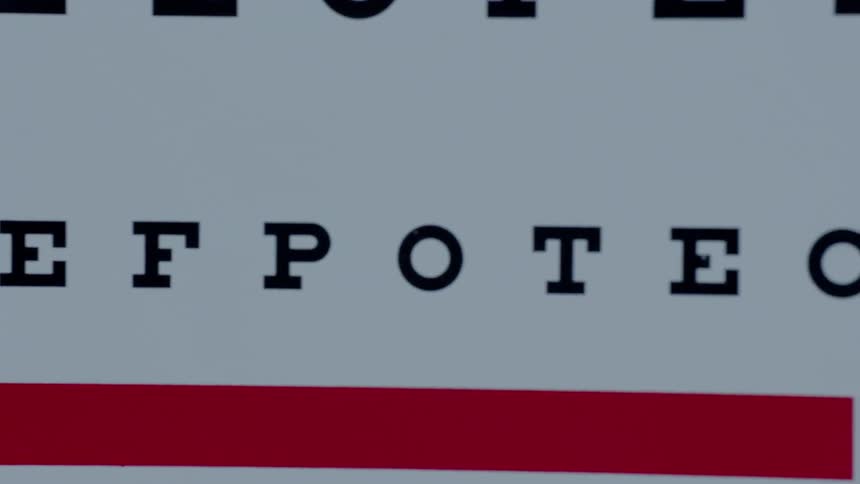 Letters and a red bar are being displayed on an eye exam chart