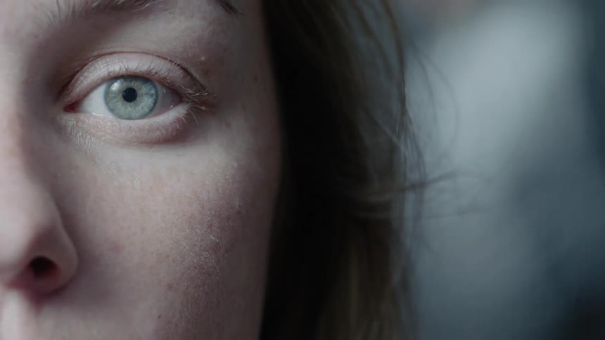 A woman is opening her eye wide and staring